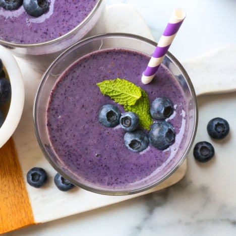 blueberry smoothie topped with berries and mint.