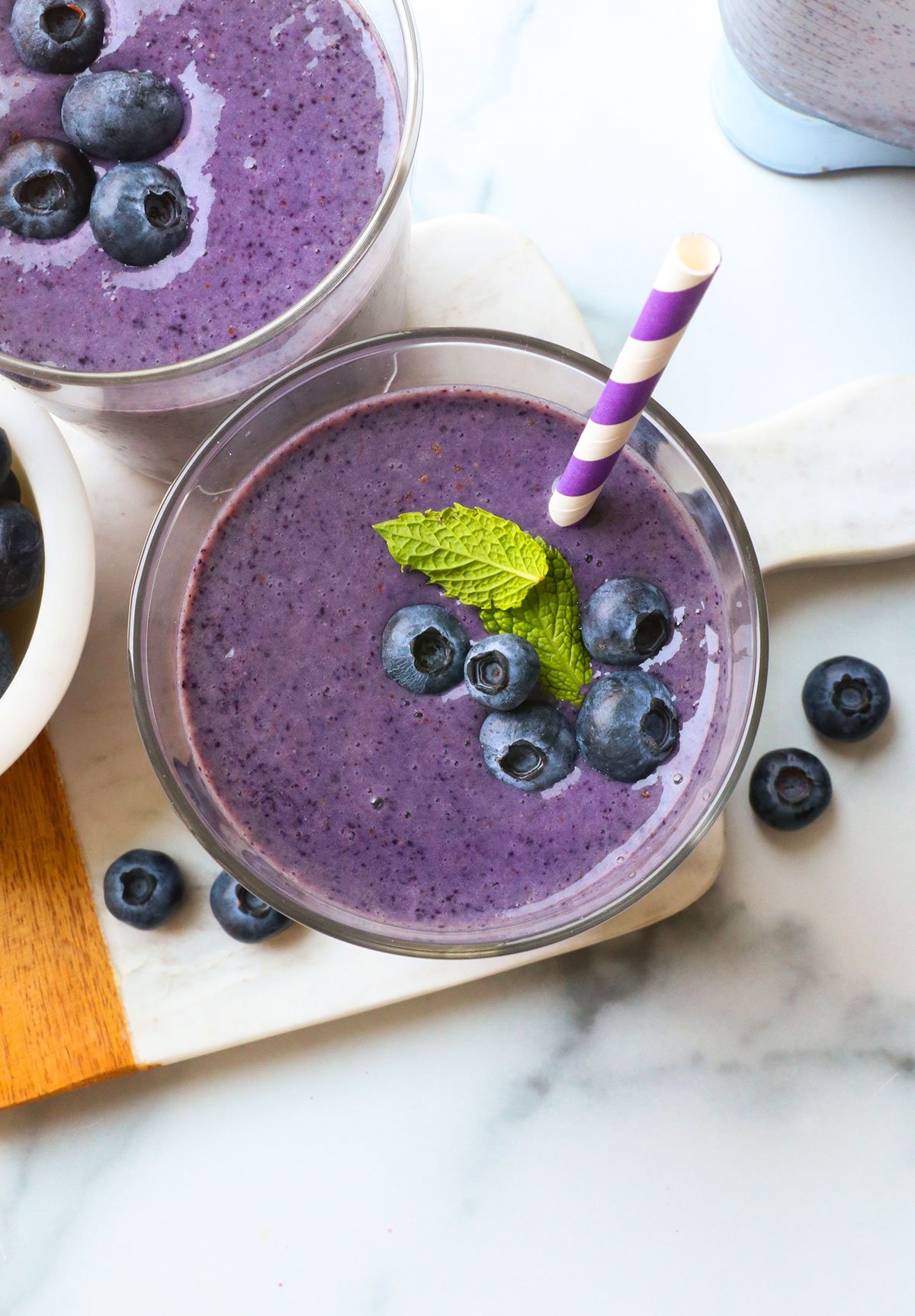 blueberry smoothie topped with berries and mint.