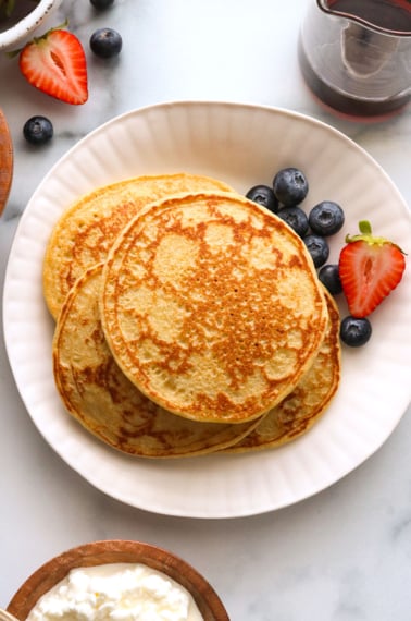 cottage cheese pancakes on a plate with berries.