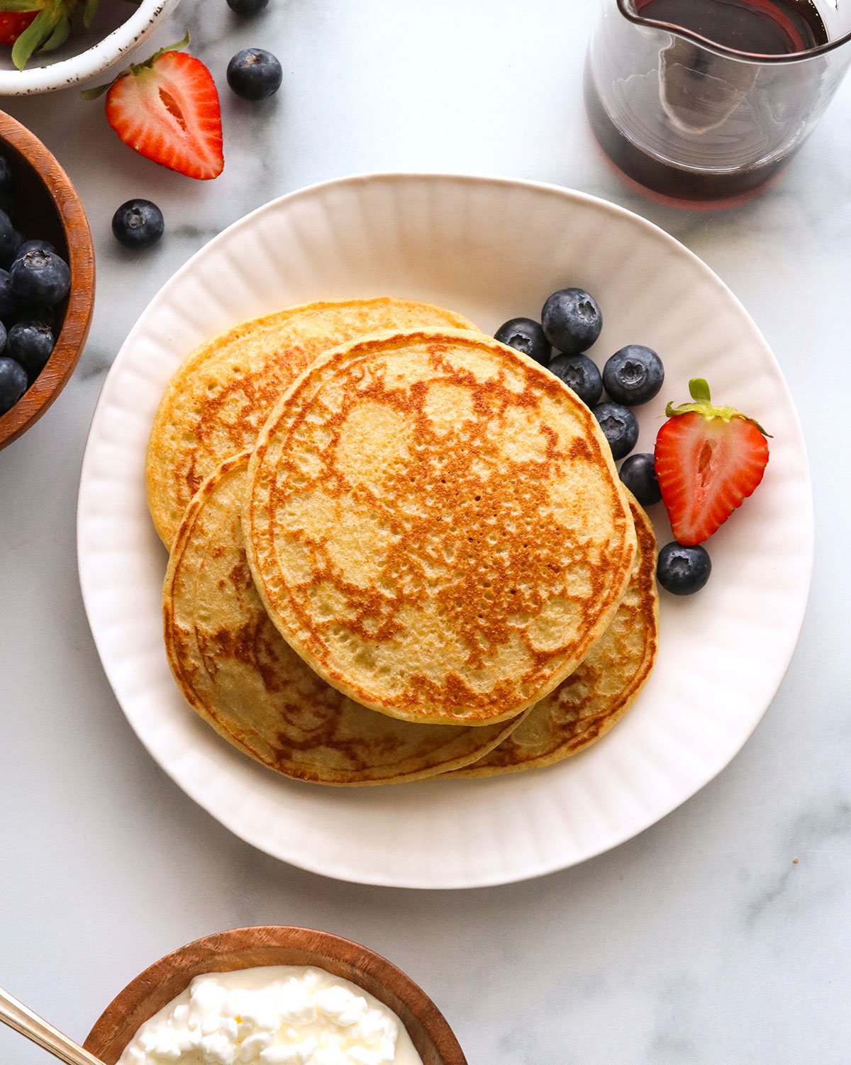 Cheese pancakes on a plate with berries.