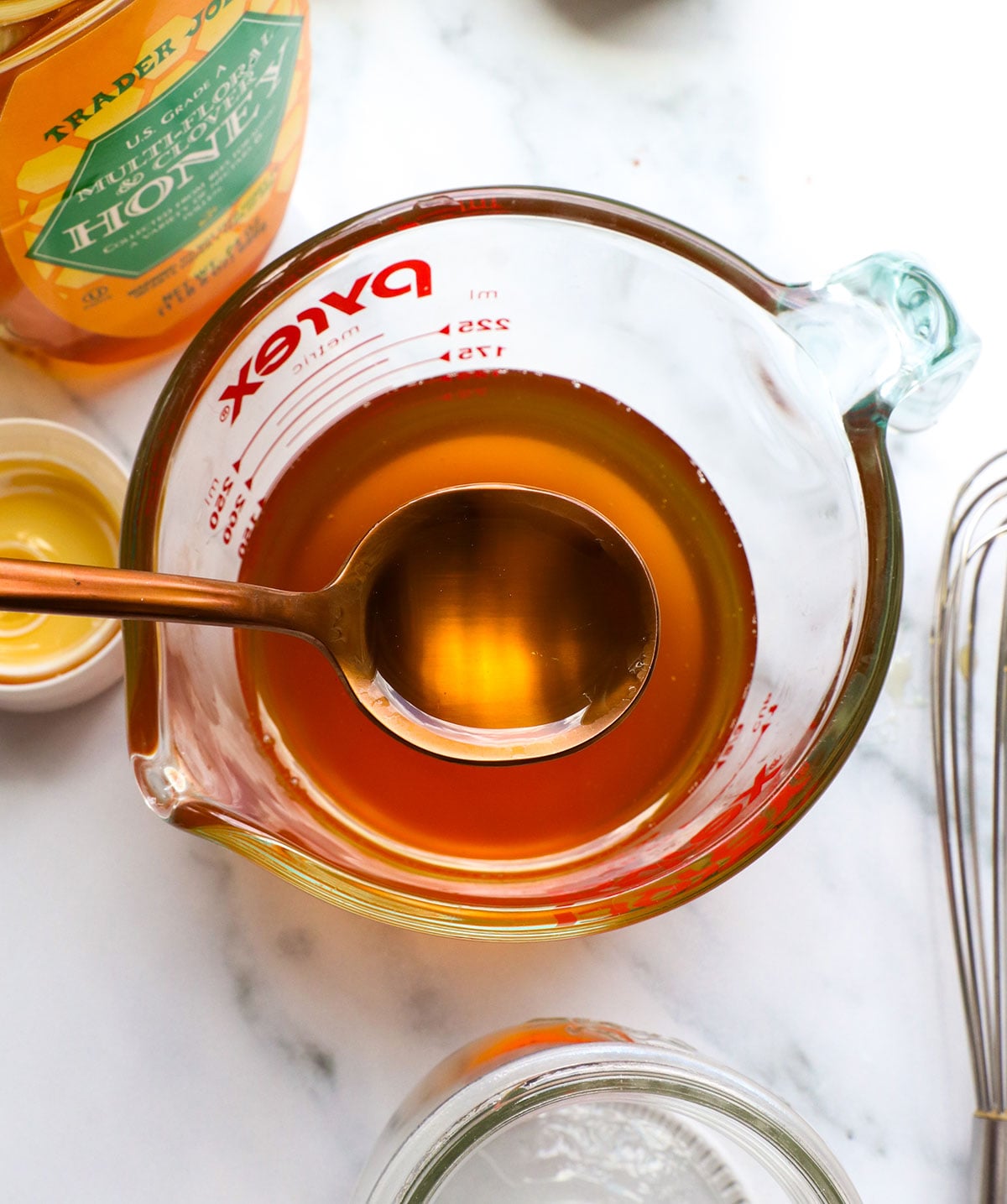 honey simple syrup lifted on a spoon.