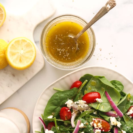 lemon vinaigrette in a jar near a salad.