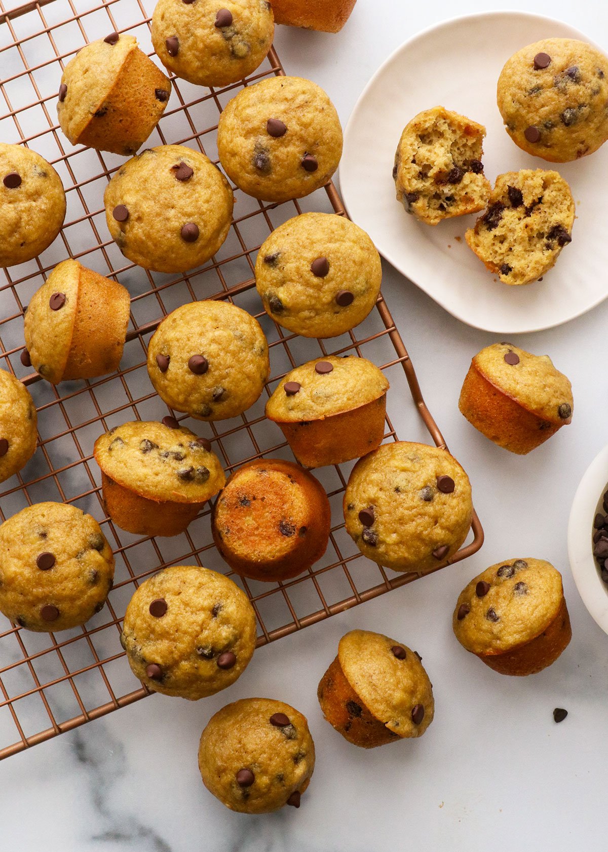 mini banana chocolate chip muffins cooling on a wire rack. 