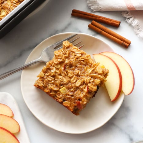 slice of apple baked oatmeal on a white plate with a fork.