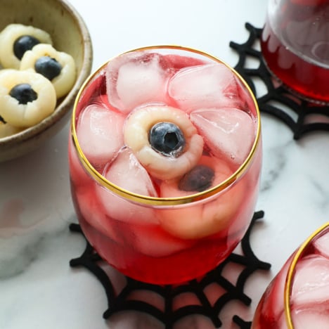 lychee eyeballs floating in a red punch glass with ice.