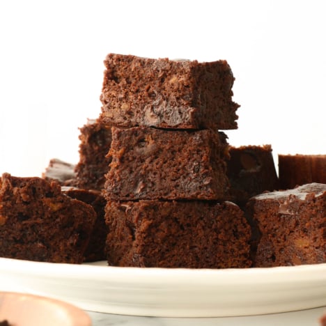 flourless sweet potato brownies stacked on a white plate.