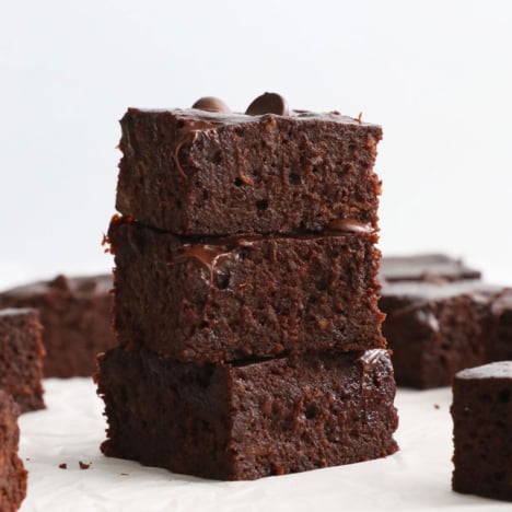 fudgy sweet potato brownies stacked on a white surface.