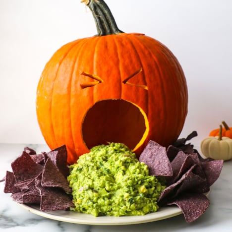 puking pumpkin guacamole appetizer with blue corn tortilla chips