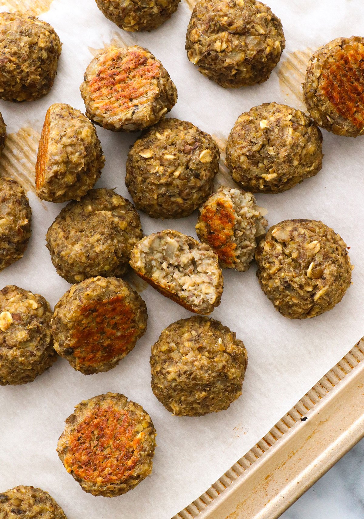 vegetarian meatballs cut in half on a pan to show texture.