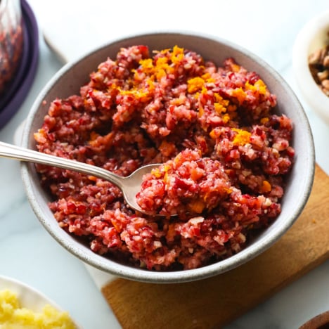 cranberry relish topped with orange zest and served with a spoon.