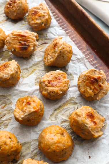 finished baked turkey meatballs on a lined pan.