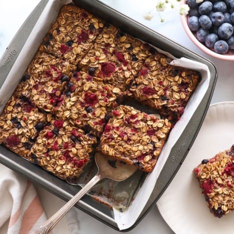 berry baked oatmeal sliced in a square pan.