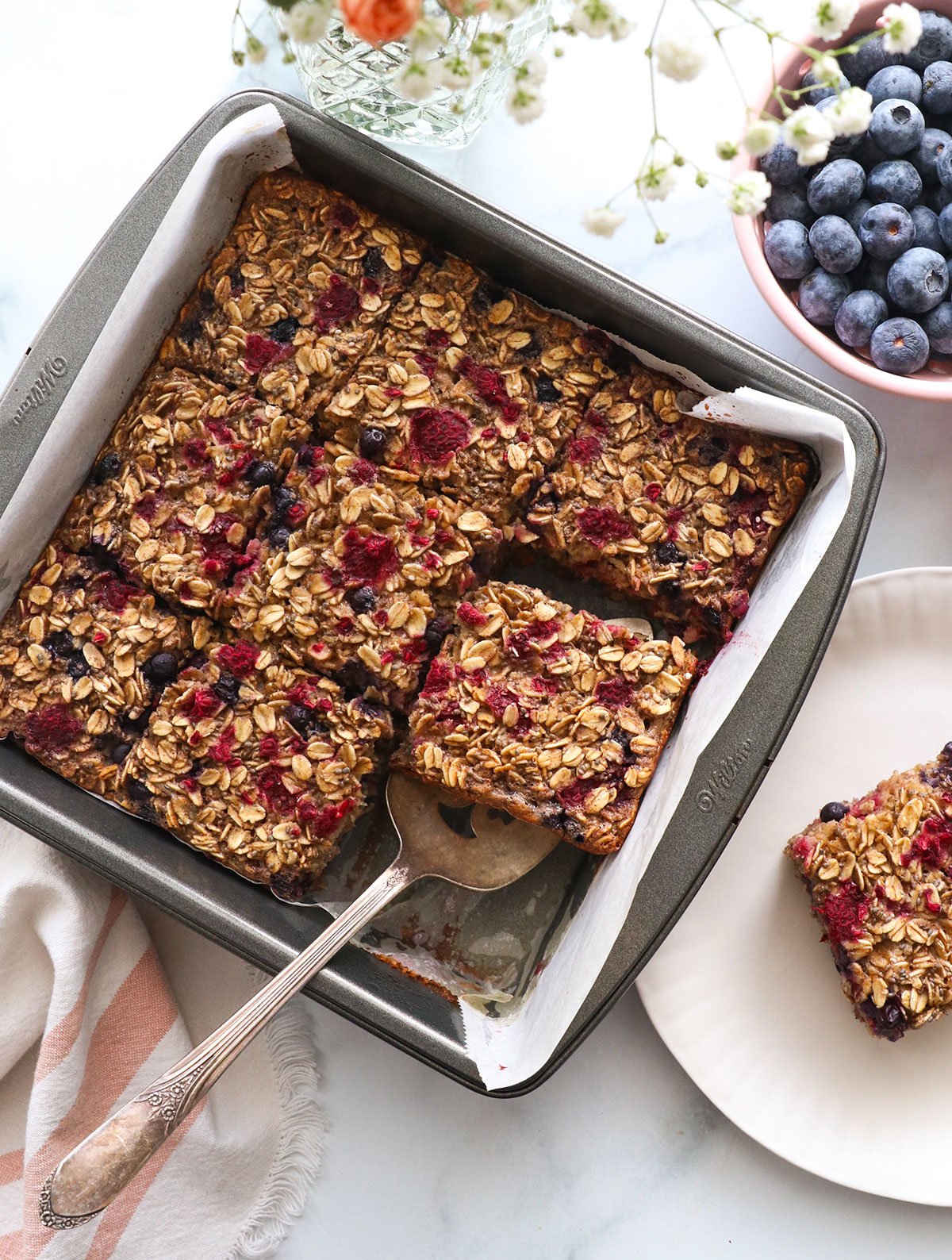 berry baked oatmeal sliced in a square pan.