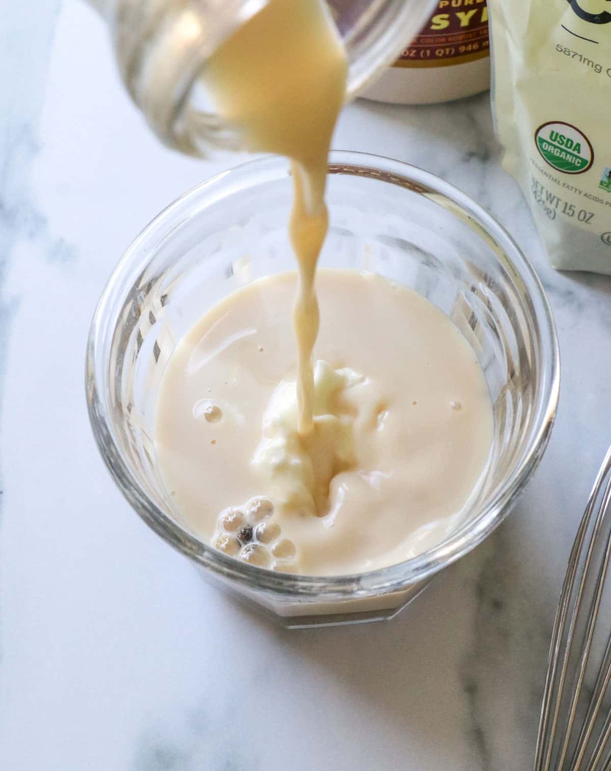 milk poured into a glass jar with yogurt and chia seeds.