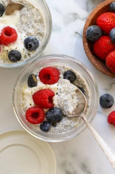 Greek yogurt chia pudding served with berries and a spoon.