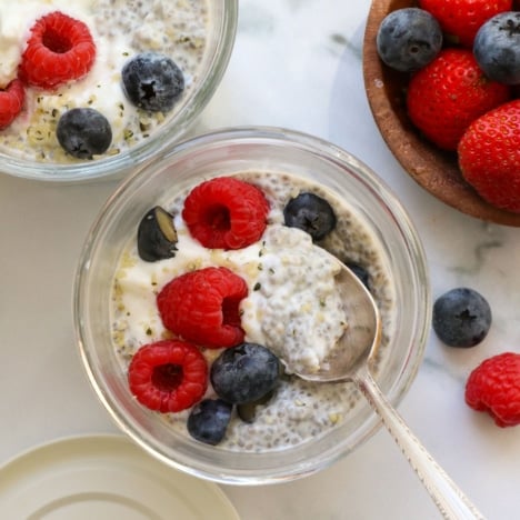 Greek yogurt chia pudding served with berries and a spoon.