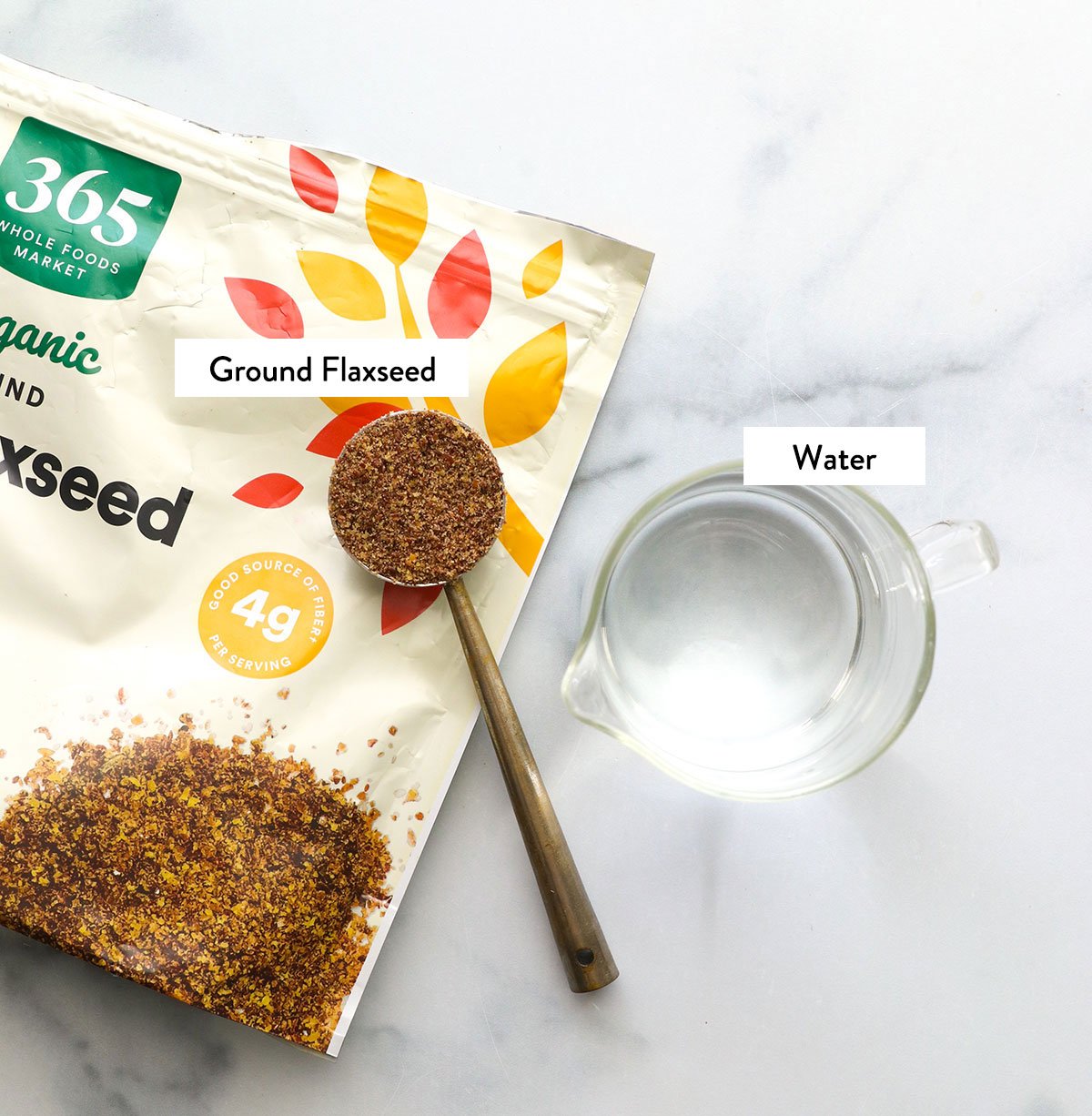 tablespoon of ground flax seed and water labeled on a counter.