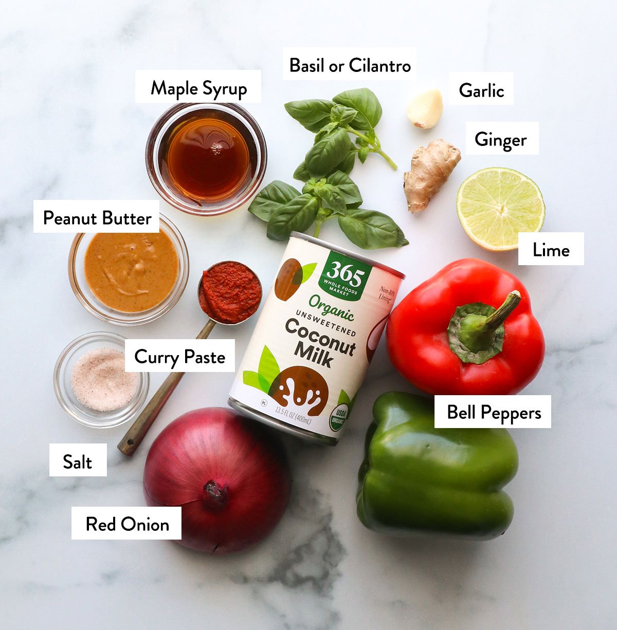 coconut milk, bell peppers, curry paste, peanut butter, and seasonings labeled on a white surface.