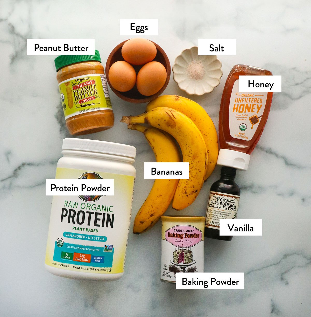 protein banana muffin ingredients labeled on a white surface.