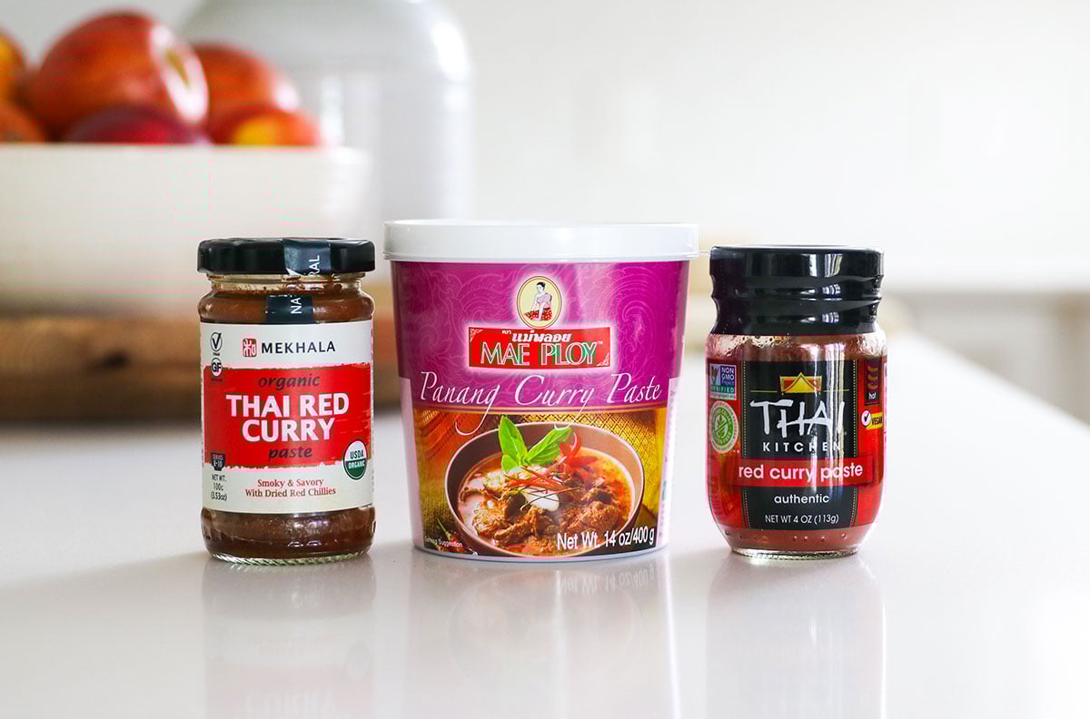 red curry paste containers on a white counter.