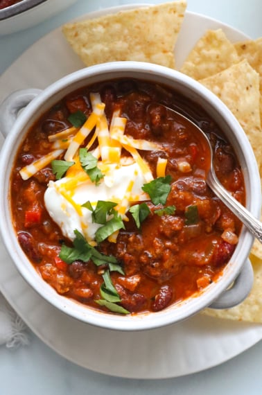 bowl of turkey chili close up with greek yogurt and cilantro on top.