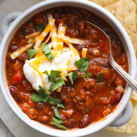 bowl of turkey chili close up with greek yogurt and cilantro on top.