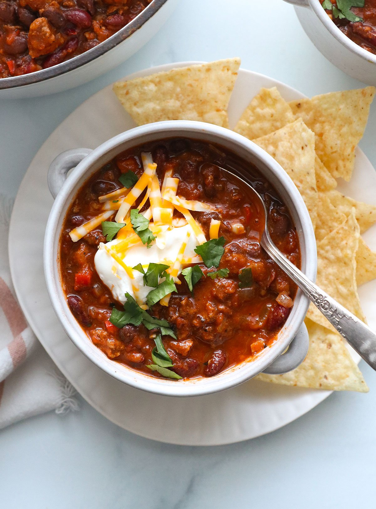 turkey chili topped with greek yogurt, cheese, and cilantro.