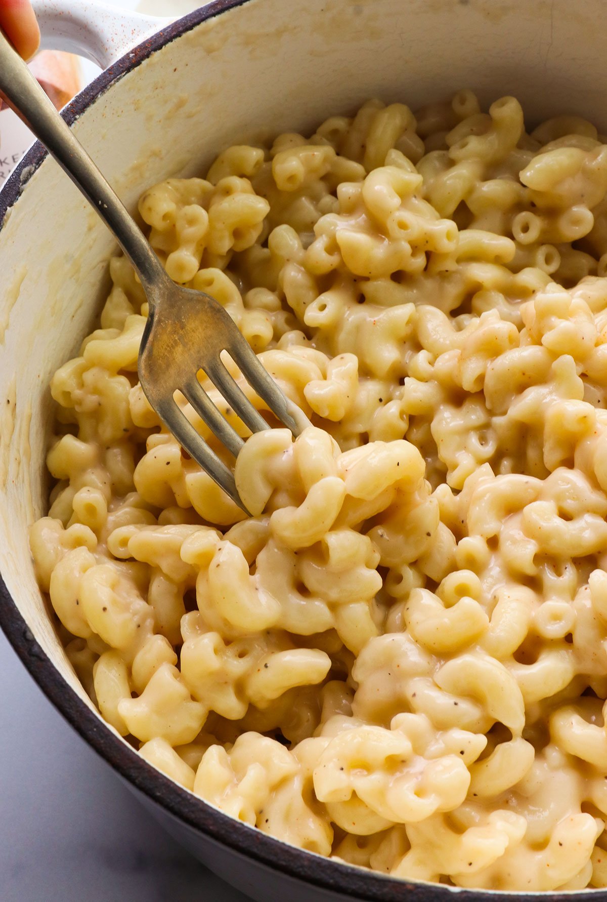 healthy mac and cheese with a fork in the pot.