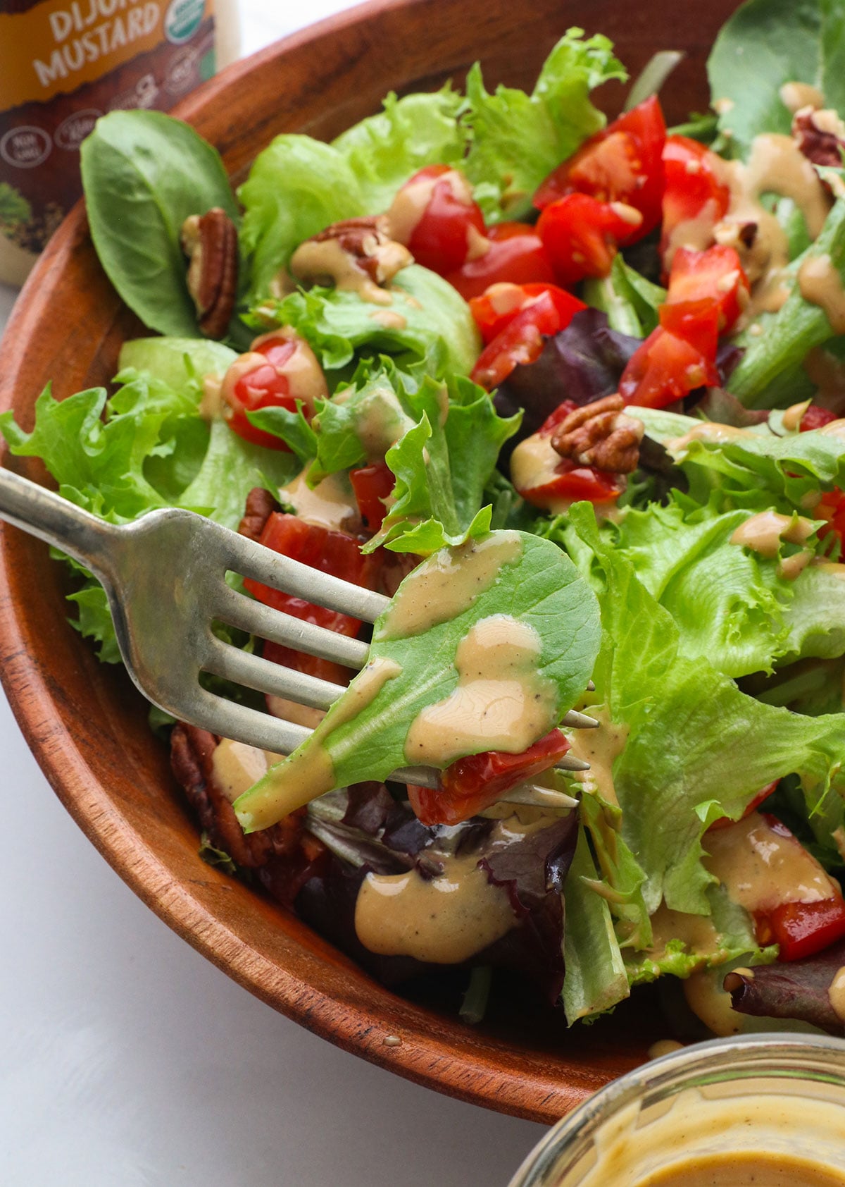 Vinaigrette balsamica al miele spalmata su una foglia di lattuga con una forchetta. 