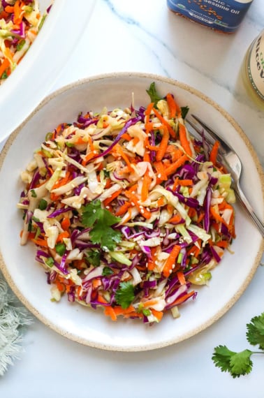 asian slaw with cilantro on a white plate.
