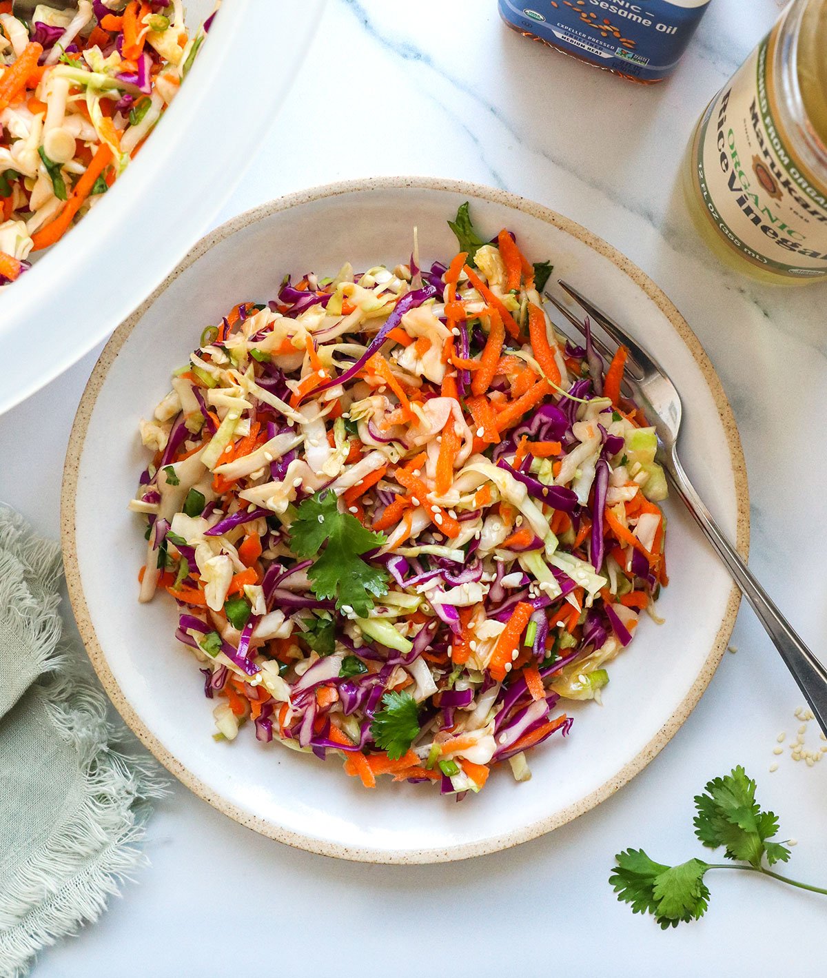 asian slaw with cilantro on a white plate.