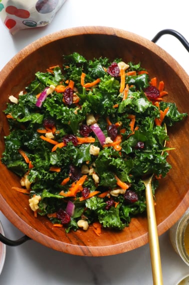 kale salad tossed with the best dressing and carrots, walnuts, and cranberries.