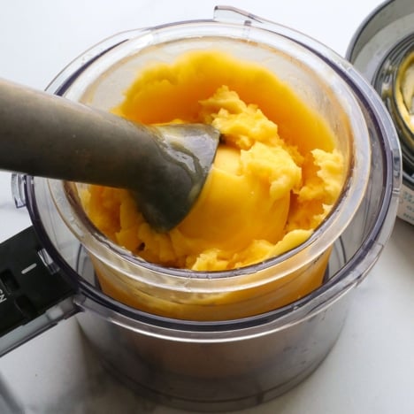 mango sorbet with an ice cream scoop in the Ninja creami bowl.