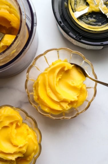 mango sorbet in two glass bowls by the Ninja Creami.