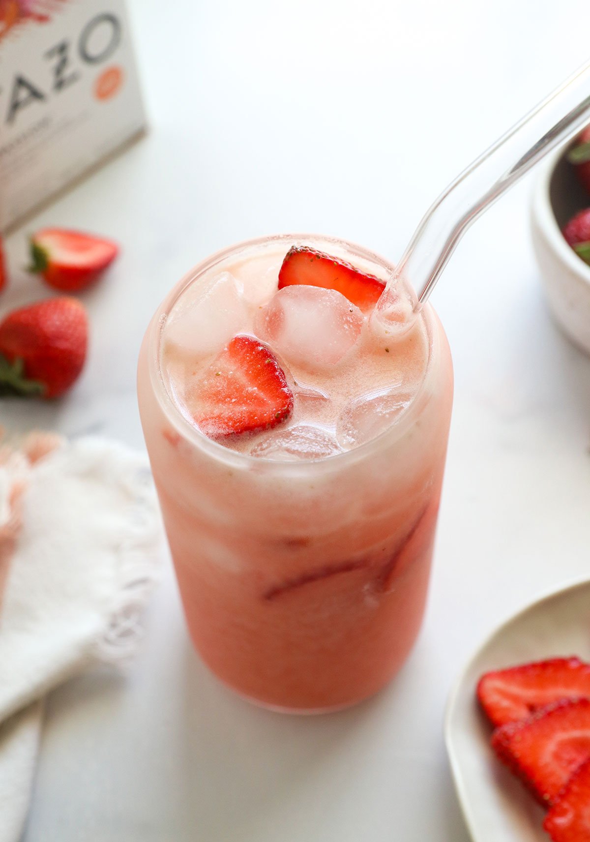 DIY pink drink in glass with fresh strawberries.