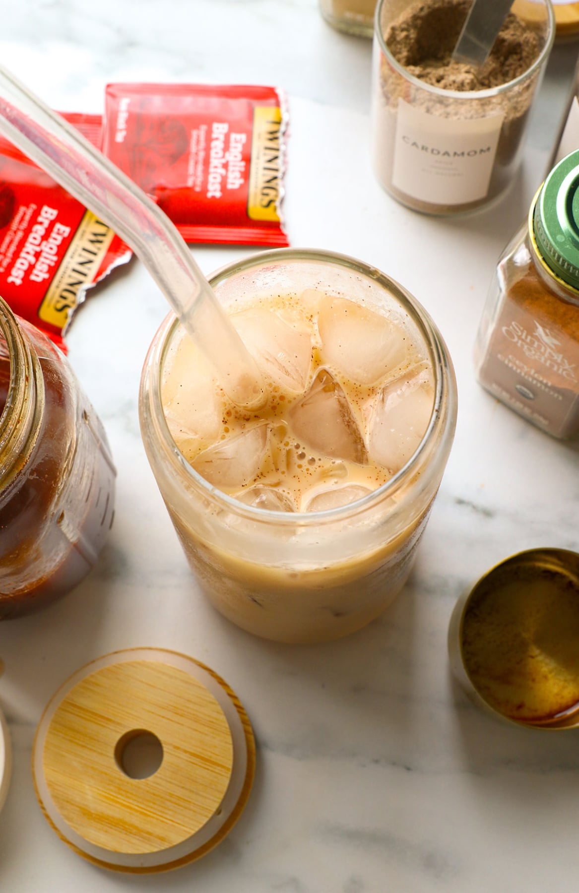 iced chai latte recipe served in a glass with a straw.
