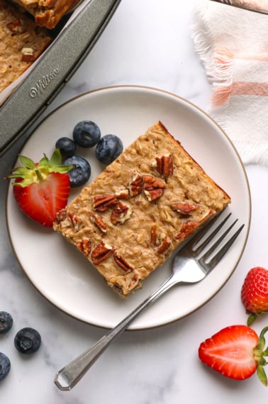 slice of protein baked oatmeal on a plate with berries.