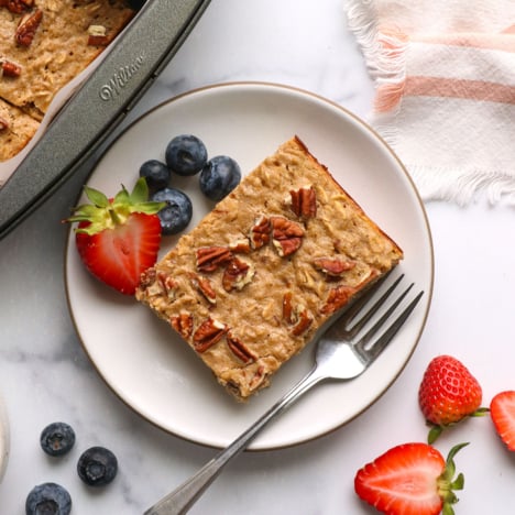 slice of protein baked oatmeal on a plate with berries.
