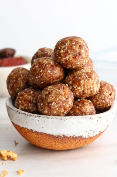 date balls stacked in a ceramic bowl.