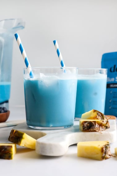 blue milk served in two glasses with blue striped straws.
