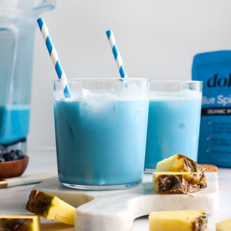 blue milk served in two glasses with blue striped straws.