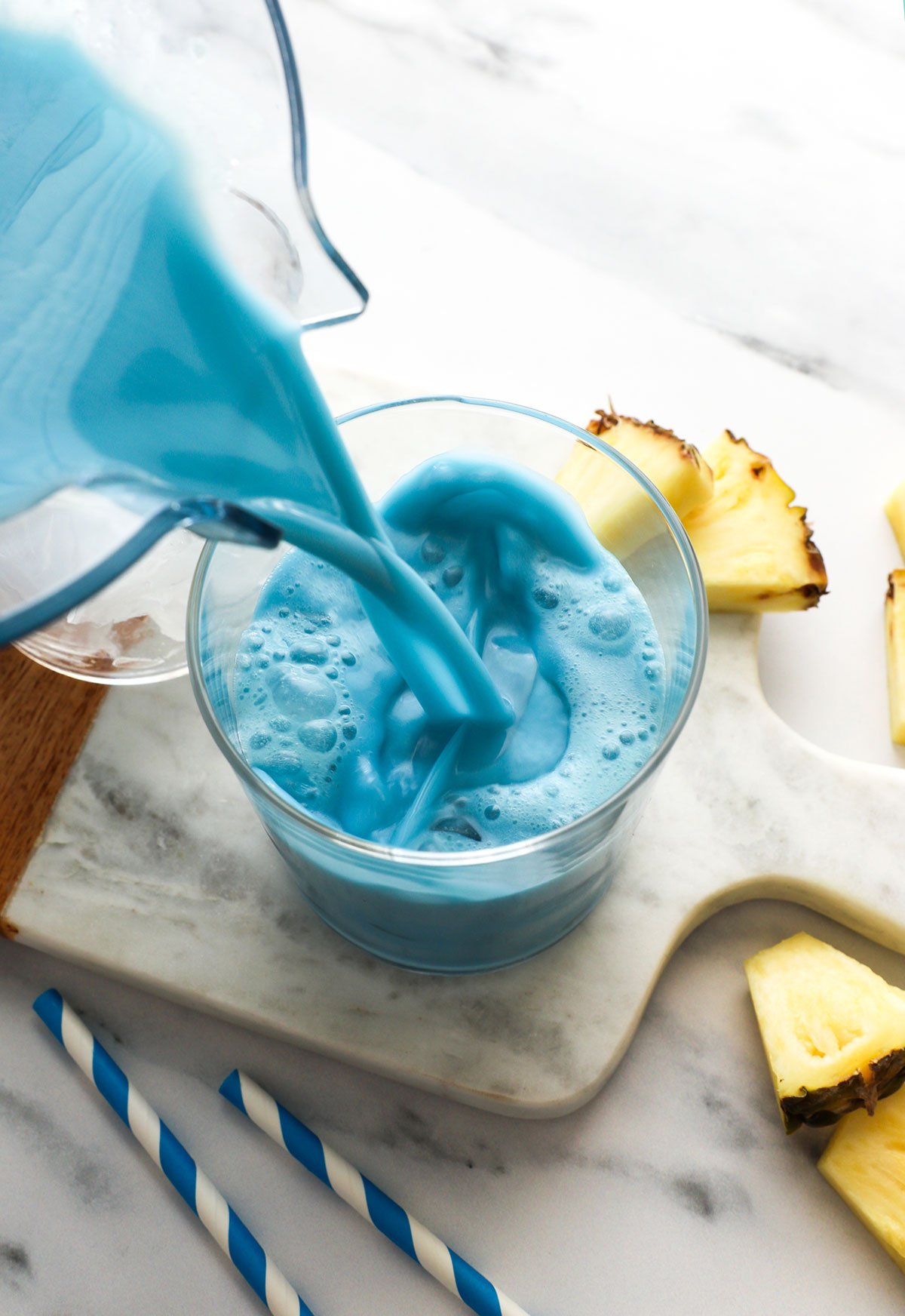 blue milk poured into a glass with ice cubes. 