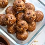 date energy balls with mini chocolate chips stored in a glass container.