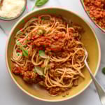 healthy spaghetti served in a bowl with fresh basil on top.