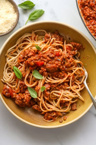 healthy spaghetti served in a bowl with fresh basil on top.