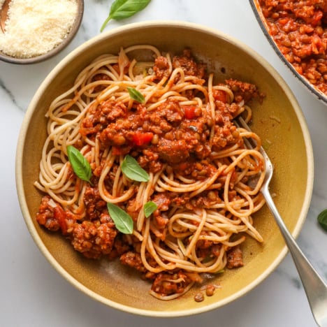 healthy spaghetti served in a bowl with fresh basil on top.