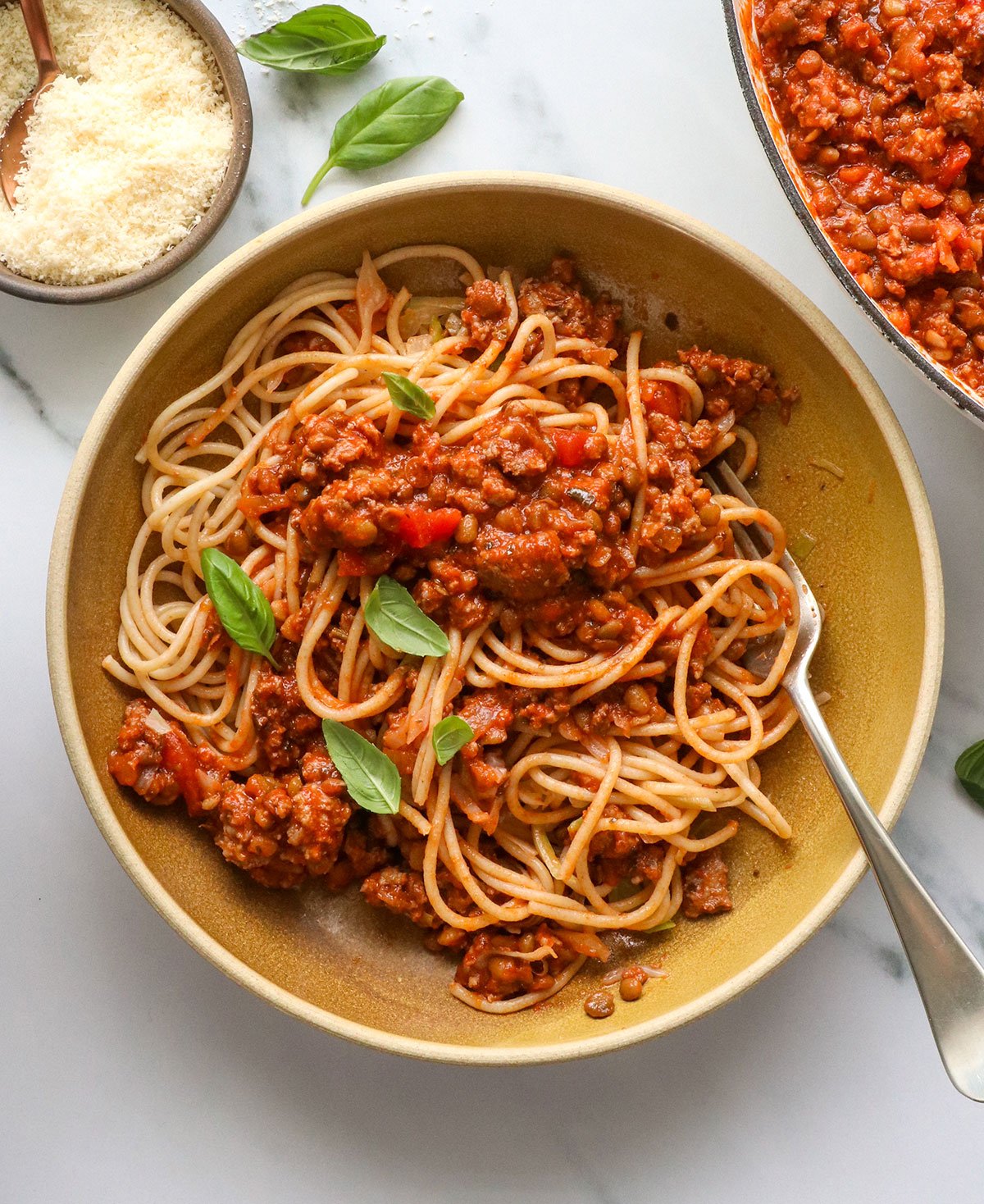 healthy spaghetti served in a bowl with fresh basil on top.