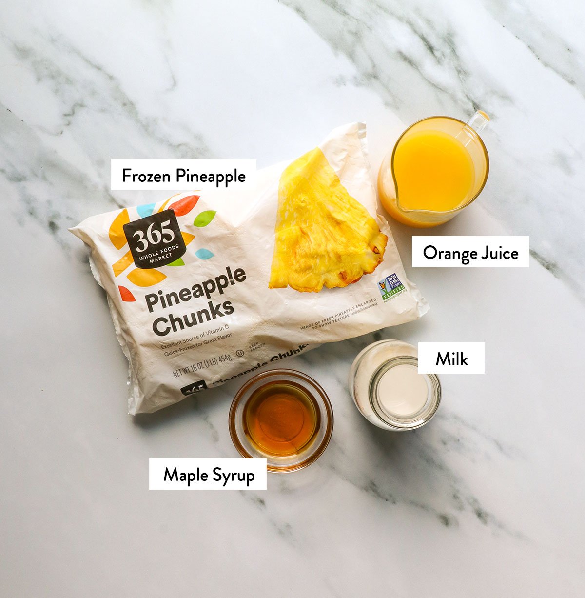 A bag of frozen pineapple, and labeled orange juice, milk and maple syrup.