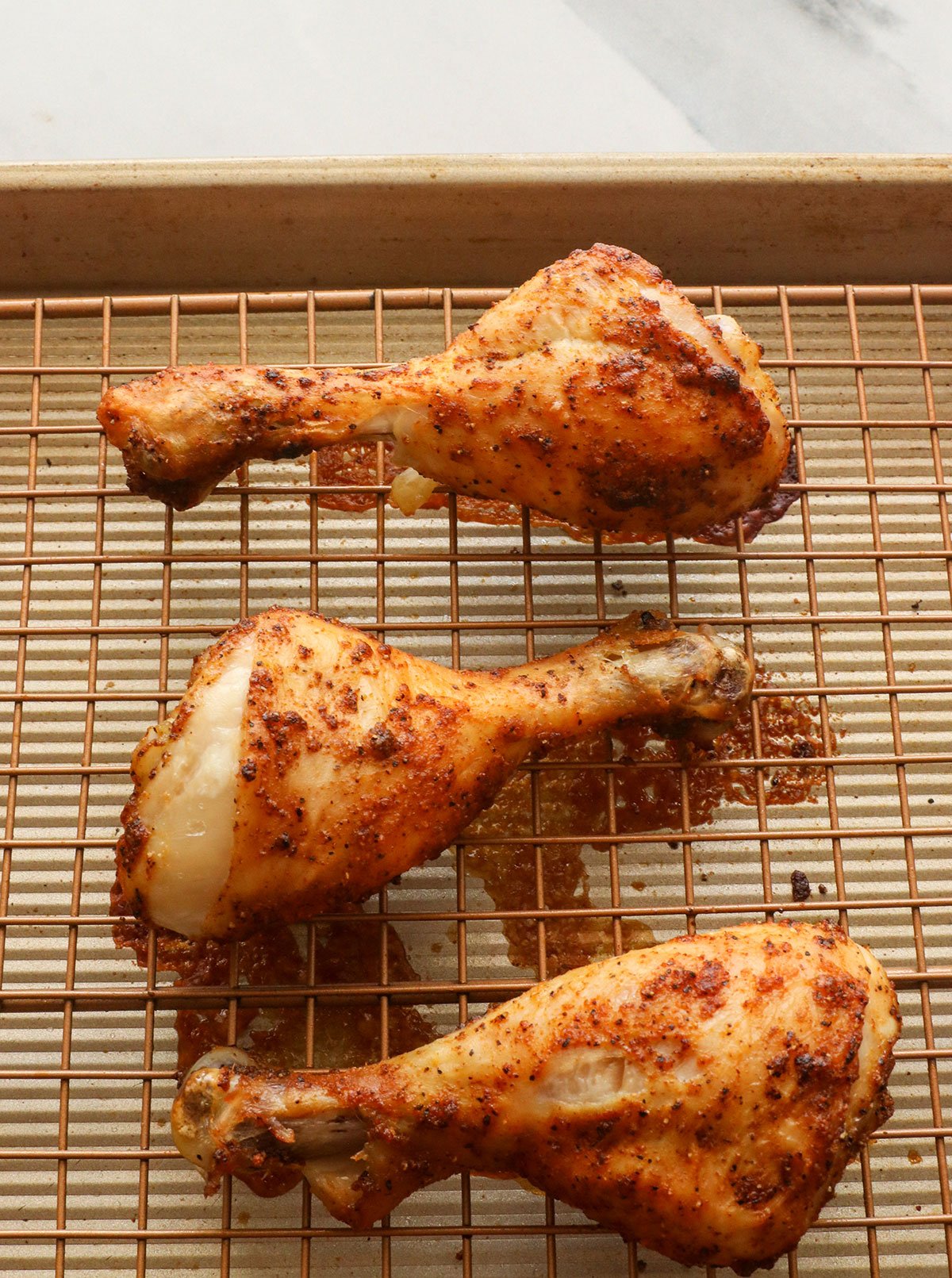 chicken drumsticks baked on a wire rack. 