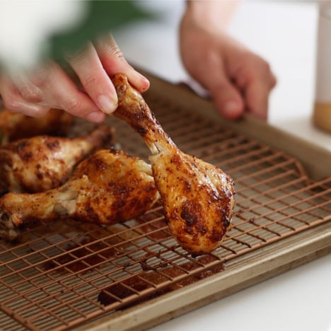 baked drumstick lifted on a wire baking sheet.